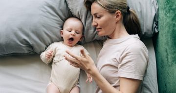 A young beautiful mother and her child are preparing to sleep during the day.