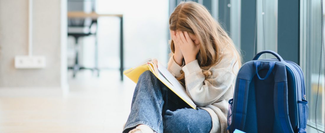 Bullying, discrimination or stress concept. Sad teenager crying in school.