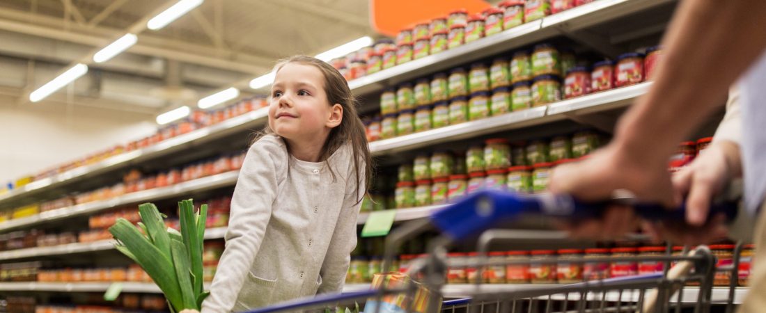 family, sale, consumerism and people concept - happy child and father carrying shopping cart buying food at grocery store