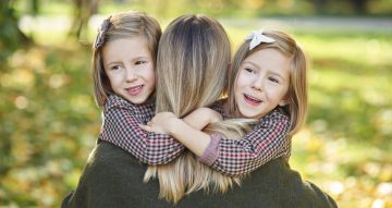 Two little girls embracing their mom